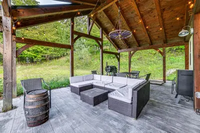a patio with a couch and chairs and a barrel at Home with Private Dock Near Colgate University in Hamilton
