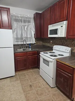 a kitchen with a white stove and a white refrigerator at Cozy Zone in Williams Bridge