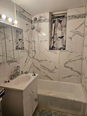 a bathroom with a tub and a sink and a shower at Cozy Zone in Williams Bridge