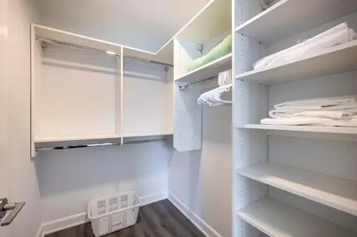 a walk in closet with white shelves and a window at Modern Apt Close to Downtown in Stamford