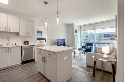 a kitchen and a living room with a table at Modern Apt Close to Downtown in Stamford