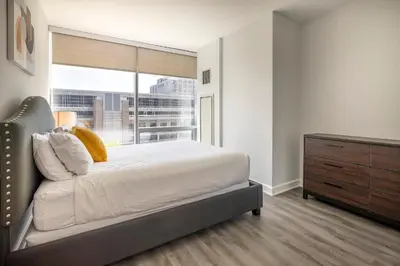 a bedroom with a bed and a dresser and a window at Modern Apt Close to Downtown in Stamford