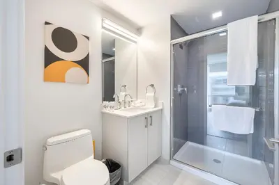 a bathroom with a shower and a toilet and a sink at Modern Apt Close to Downtown in Stamford