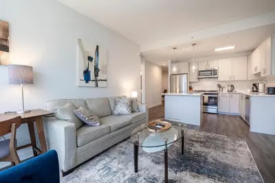 a living room and kitchen with a couch and a table at Modern Apt Close to Downtown in Stamford