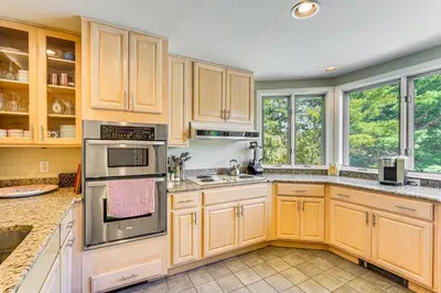 a kitchen with wooden cabinets and stainless steel appliances at Walk to Ski Lift Spacious Condo in West Dover! in West Dover
