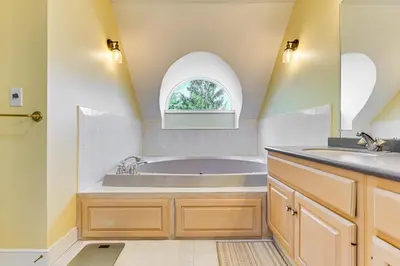 a bathroom with a tub and an arched window at Walk to Ski Lift Spacious Condo in West Dover! in West Dover