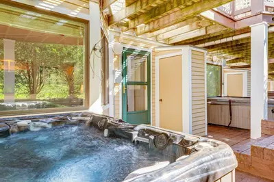 a hot tub in a house with a large window at Walk to Ski Lift Spacious Condo in West Dover! in West Dover