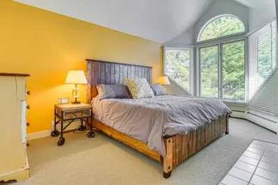 a bedroom with a large bed and two windows at Walk to Ski Lift Spacious Condo in West Dover! in West Dover