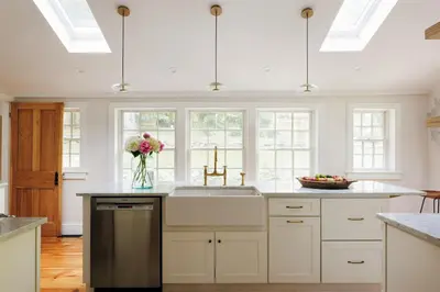 a kitchen with white cabinets and a sink and windows at Stylish Rural Sanctuary Perfect for Every Season! in East Chatham