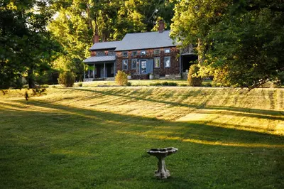 a house in the middle of a yard with a bird bath in the grass at Stylish Rural Sanctuary Perfect for Every Season! in East Chatham