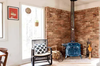 a room with a brick wall and a blue stove at Relaxing Hudson Valley Getaway- 4BR Sauna 15 acres in Stone Ridge