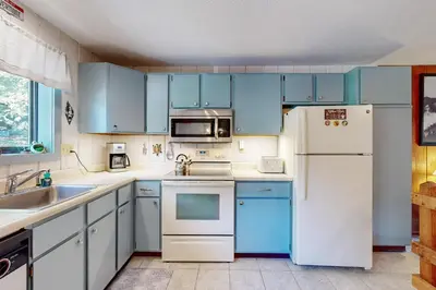 a kitchen with blue cabinets and a white refrigerator at Dover Green 15F in Dover
