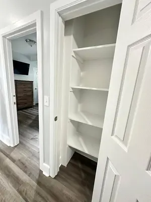 a closet with white shelves in a room at Pitcher's Paradise Apt 1-All Star Baseball Rentals in Oneonta
