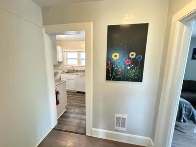 a hallway with a painting of flowers on the wall at Pitcher's Paradise Apt 2-All Star Baseball Rentals in Oneonta