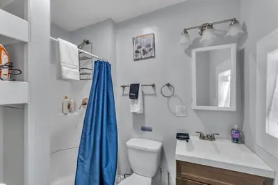 a bathroom with a toilet and a sink and a mirror at Pitcher's Paradise Apt 2-All Star Baseball Rentals in Oneonta