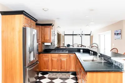 a kitchen with wooden cabinets and a black counter top at Vermont Ski Home Lake Home in Jacksonville