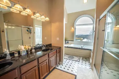 a bathroom with two sinks and a large mirror at Vermont Ski Home Lake Home in Jacksonville