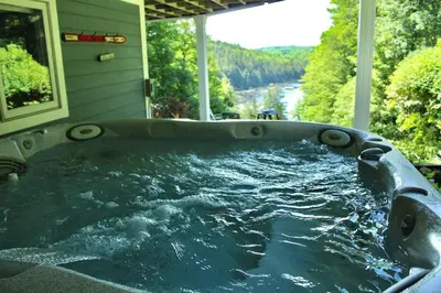 a jacuzzi tub with a view of a river at Vermont Ski Home Lake Home in Jacksonville