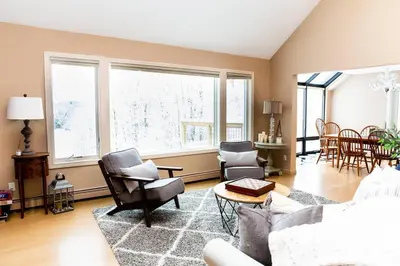 a living room with a couch and chairs and windows at Vermont Ski Home Lake Home in Jacksonville