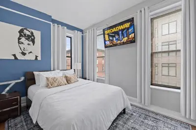 a bedroom with a bed and a large window at Hoboken 15 Min Train to Manhattan Full Kitchen in Hoboken