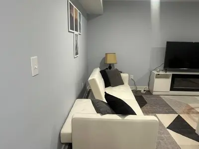 a living room with a white couch and a television at Charming Unit in Yonkers Close to NYC in Yonkers