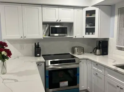 a kitchen with white cabinets and a stove top oven at Charming Unit in Yonkers Close to NYC in Yonkers