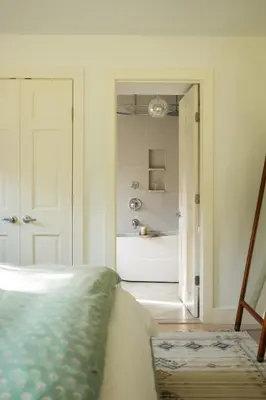a bedroom with a bed and a bathroom with a tub at Stunning All-Season Renovated Barn Escape! in East Chatham