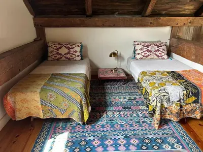 a room with two beds and a rug at Stunning All-Season Renovated Barn Escape! in East Chatham