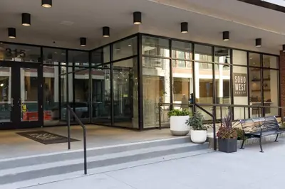 a glass building with a bench in front of it at Modern Loft 15 Min from NYC with City View & Pool in Croxton