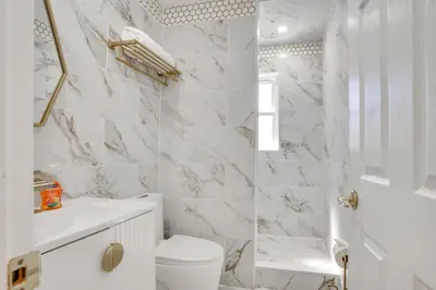 a white bathroom with a toilet and a sink at 4 Mi to NYC, Shared Yard Englewood Apartment! in Englewood