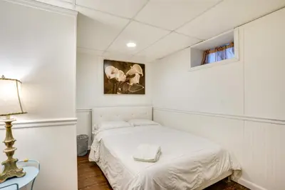 a white bedroom with a bed and a window at Shared Yard, 4 Mi to NYC Englewood Apartment! in Englewood