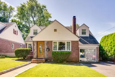 a home with a brick house with a yellow door at Shared Yard, 4 Mi to NYC Englewood Apartment! in Englewood