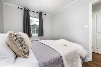 a white bedroom with a bed and a window at Queen Bed Apt in West Hartford in West Hartford