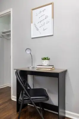 a black desk with a chair and a sign on a wall at Queen Bed Apt in West Hartford in West Hartford