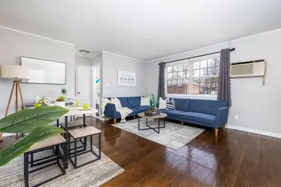 a living room with a blue couch and a table at Queen Bed Apt in West Hartford in West Hartford