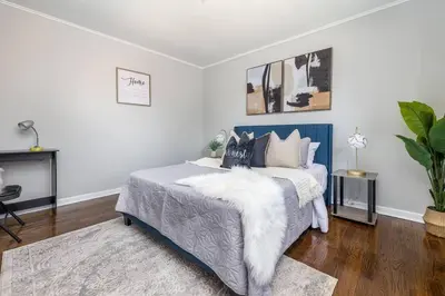a bedroom with a bed with a blue headboard at Queen Bed Apt in West Hartford in West Hartford