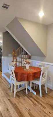 a dining room table with white chairs and a staircase at Sparta lakehouse in Sparta