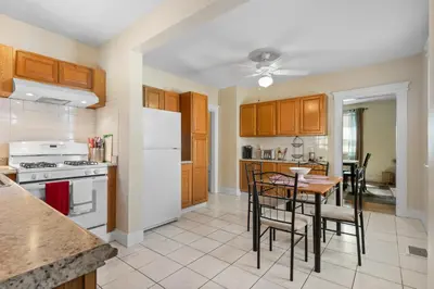 a kitchen with wooden cabinets and a table with chairs at UNH Home Base 10 minutes from beach in West Haven