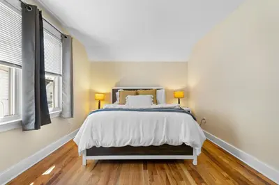 a bedroom with a bed and two windows at UNH Home Base 10 minutes from beach in West Haven