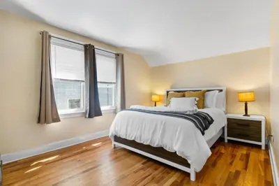 a bedroom with a bed and two windows at UNH Home Base 10 minutes from beach in West Haven