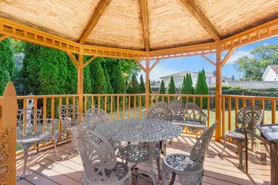 a patio with a table and chairs on a wooden deck at 3BR Gem, 10 min to Yale, walk to Tweed in New Haven
