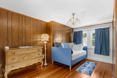 a bedroom with a blue chair and a dresser and a window at 3BR Gem, 10 min to Yale, walk to Tweed in New Haven