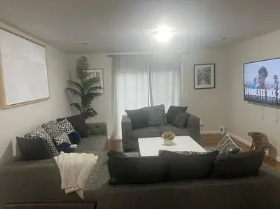a living room with a couch and a table at Exquisite 4 Beds Near EWR NYC in East Orange