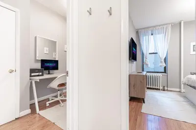 a bedroom with a bed and a desk with a computer at Chic 3Bd 1Bth Near Empire State in New York