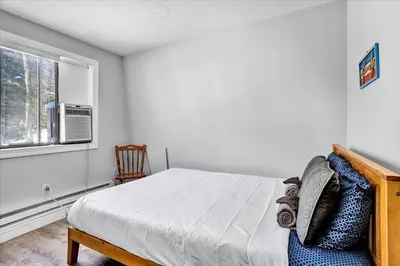 a bedroom with a bed and a window at Pet Friendly! Lakefront w Hot Tub, Firepit! in Tobyhanna