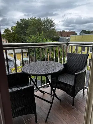 a patio table and two chairs on a balcony at Modern minimalistic 3 bdr Apt Townhouse in Jersey City