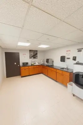 a large room with a kitchen with wooden cabinets at Floral Park Motor Lodge in Floral Park