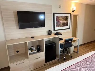 a room with a desk with a television on a wall at Floral Park Motor Lodge in Floral Park
