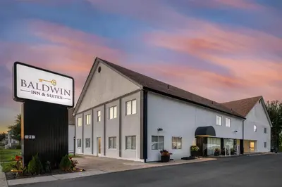a building with a sign for a ballining inn and suites at Baldwin Inn & Suites, SureStay Collection by Best Western in West Springfield
