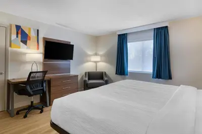 a hotel room with a bed and a desk and a television at Baldwin Inn & Suites, SureStay Collection by Best Western in West Springfield